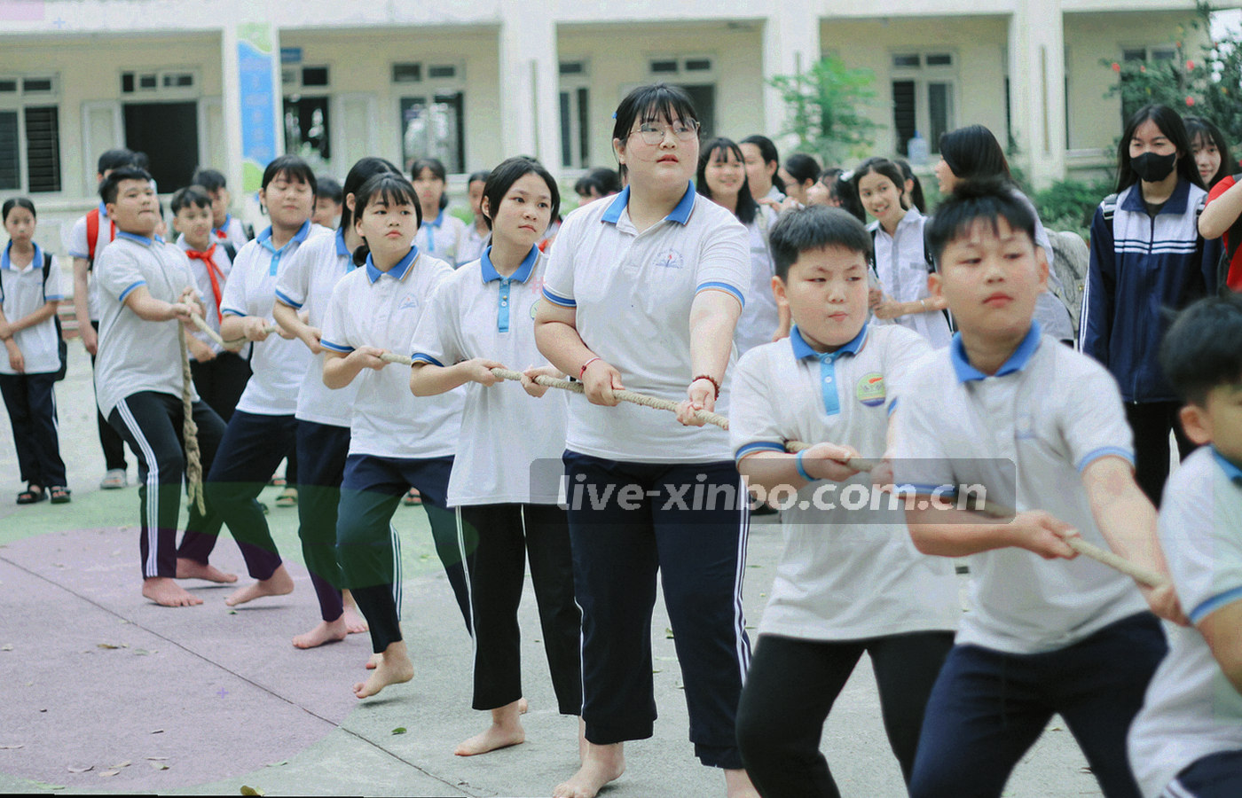 夜间场馆通道里的灯光纵深与地面反光，通道尽头隐约可见场地轮廓